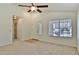 Inviting living room with neutral carpet, a ceiling fan, a window, and easy access to other rooms at 44917 W Zion Rd, Maricopa, AZ 85139