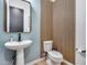 Chic powder bathroom with a pedestal sink, wood accent wall and wood-look flooring at 4606 S Ferric --, Mesa, AZ 85212