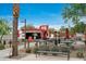 Outdoor dining area with picnic tables, string lights, and shade umbrellas next to a restaurant at 4606 S Ferric --, Mesa, AZ 85212