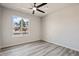 Bright bedroom featuring neutral paint, window, and gray wood-look floors at 5431 W Sierra St, Glendale, AZ 85304