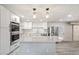Updated kitchen with white cabinetry, stainless steel appliances, and a center island with quartz countertop at 5431 W Sierra St, Glendale, AZ 85304