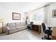A cozy living room with a couch, desk and chair, and a window with curtains at 5525 E Thomas Rd # N5, Phoenix, AZ 85018