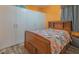 Bedroom with a wooden bed, closet with modern sliding doors, and orange walls at 560 S 197Th Ave, Buckeye, AZ 85326