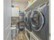 Efficient laundry room with a large washer and dryer, sink, storage, and contemporary wood-look flooring at 560 S 197Th Ave, Buckeye, AZ 85326