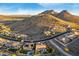 A high angle view of a luxury home with a pool and detailed landscaping in a mountainous neighborhood at 6022 W Fetlock Trl, Phoenix, AZ 85083