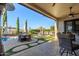 Back patio overlooking an outdoor kitchen, pool, and manicured landscaping at 6022 W Fetlock Trl, Phoenix, AZ 85083
