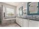 Bright bathroom featuring a double sink vanity, a soaking tub, and a glass-enclosed shower at 6022 W Fetlock Trl, Phoenix, AZ 85083