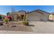 Attractive single-story home showcasing desert landscaping, an American flag, and a three-car garage at 6022 W Fetlock Trl, Phoenix, AZ 85083