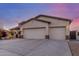 Spacious three-car garage with extended driveway and stylish exterior lighting at 6022 W Fetlock Trl, Phoenix, AZ 85083