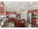 Spacious kitchen featuring cherry wood cabinets, stainless steel appliances and a center island with seating at 6022 W Fetlock Trl, Phoenix, AZ 85083
