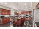Modern kitchen boasts cherry cabinets, stainless steel appliances and a large island with pendant lights at 6022 W Fetlock Trl, Phoenix, AZ 85083