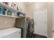 Functional laundry room with shelving, modern washer and dryer, and ample storage space at 6022 W Fetlock Trl, Phoenix, AZ 85083