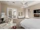 Bright main bedroom featuring a king-size bed, fireplace, ceiling fan, and a private door to the patio at 6022 W Fetlock Trl, Phoenix, AZ 85083