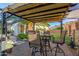 Outdoor seating area under a covered patio, with lawn and landscaping visible in the background at 6022 W Fetlock Trl, Phoenix, AZ 85083