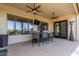 This covered patio offers a ceiling fan, an outside bar, and a view of the desert landscape at 6022 W Fetlock Trl, Phoenix, AZ 85083