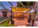 Outdoor dining area with a covered pergola and ambient string lighting at 6022 W Fetlock Trl, Phoenix, AZ 85083