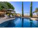 Inviting backyard pool featuring a waterfall, lounge chairs, and desert landscaping with beautiful mountain views at 6022 W Fetlock Trl, Phoenix, AZ 85083