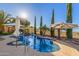 Heated pool featuring a spa, rock waterfall, desert views, and poolside umbrellas at 6022 W Fetlock Trl, Phoenix, AZ 85083