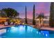 Private pool featuring a rock waterfall, cypress trees, and desert views at 6022 W Fetlock Trl, Phoenix, AZ 85083