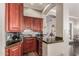 A modern wet bar area featuring dark wood cabinets, granite countertops, and stainless steel appliances at 6022 W Fetlock Trl, Phoenix, AZ 85083