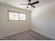 The bedroom has a ceiling fan, new carpet flooring, and a window at 6565 N 19Th Ave # 59, Phoenix, AZ 85015