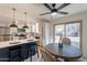 Open-concept kitchen and dining area with stainless steel appliances, a dark island, and modern light fixtures at 6565 N 19Th Ave # 59, Phoenix, AZ 85015