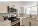 Close-up of a well-equipped kitchen with stainless steel appliances and stylish white cabinetry at 6565 N 19Th Ave # 59, Phoenix, AZ 85015