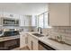 Bright kitchen featuring stainless steel appliances, white cabinets, and subway tile backsplash at 6565 N 19Th Ave # 59, Phoenix, AZ 85015