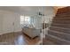 Stylish living room with wood floors, staircase, and bright windows looking out into the complex at 6565 N 19Th Ave # 59, Phoenix, AZ 85015