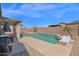 A backyard features a covered patio area, swimming pool, and beautiful desert landscaping at 6904 W Golden Ln, Peoria, AZ 85345