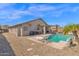 This backyard includes a covered patio, an outdoor swimming pool, and desert landscaping at 6904 W Golden Ln, Peoria, AZ 85345