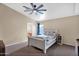 Cozy bedroom featuring neutral paint, ceiling fan, and ensuite bathroom entrance at 6904 W Golden Ln, Peoria, AZ 85345