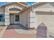 Close up of a home's entrance and garage, showcasing the brick-paved walkway and neutral color scheme at 6904 W Golden Ln, Peoria, AZ 85345