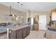 Bright, open-concept kitchen with an island, stainless steel fridge, and seamless flow to the living area at 6904 W Golden Ln, Peoria, AZ 85345