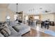 Open-concept living space with gray sectional, kitchen island with seating, stainless steel appliances, and dining area at 6904 W Golden Ln, Peoria, AZ 85345