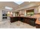 A gourmet kitchen features stainless steel appliances, an island and bright natural light from a skylight at 7330 E Palo Verde Dr # 1, Scottsdale, AZ 85250