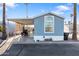 Inviting light blue home featuring carport, convenient trash receptacle and manicured desert landscaping at 7807 E Main St # E-38, Mesa, AZ 85207