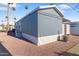 Side view of light blue home with desert landscaping and carport, complemented by palm trees at 7807 E Main St # E-38, Mesa, AZ 85207