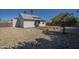 Exterior view of a home backyard with gravel landscaping, a covered patio, and an orange tree at 801 E Piute Ave, Phoenix, AZ 85024