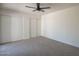 Spacious bedroom featuring modern ceiling fan, neutral carpeting and bright white walls at 801 E Piute Ave, Phoenix, AZ 85024