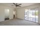 Open main bedroom leading to backyard and bathroom featuring modern ceiling fan and neutral carpeting at 801 E Piute Ave, Phoenix, AZ 85024