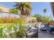 Backyard featuring built-in kitchen, mature landscaping, and hardscaping at 816 E Amberwood Dr, Phoenix, AZ 85048