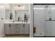 Bright bathroom featuring a large mirror, gray cabinets, and a glass-enclosed shower at 816 E Amberwood Dr, Phoenix, AZ 85048