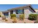 View of the home's facade showing a rock garden with young tree and shrubbery in front of the large window at 816 E Amberwood Dr, Phoenix, AZ 85048