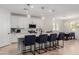 Modern open-concept kitchen with pendant lighting, white cabinets, stainless appliances and breakfast bar seating at 816 E Amberwood Dr, Phoenix, AZ 85048