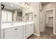 Bathroom featuring double sinks with white cabinetry, a large mirror and wood-look flooring at 8515 W Peppertree Ln, Glendale, AZ 85305