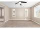 Bedroom featuring neutral carpet, a ceiling fan, two windows, and a built-in bench at 8515 W Peppertree Ln, Glendale, AZ 85305