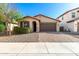 Charming single-story home featuring a desert landscape and a brick-paved driveway leading to a two-car garage at 8515 W Peppertree Ln, Glendale, AZ 85305
