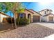 Well-maintained single-story home with desert landscaping and a brick driveway, showcasing a neat and attractive exterior at 8515 W Peppertree Ln, Glendale, AZ 85305