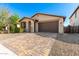 Attractive single-story home featuring low-maintenance desert landscaping and a brick-paved driveway, offering easy curb appeal at 8515 W Peppertree Ln, Glendale, AZ 85305